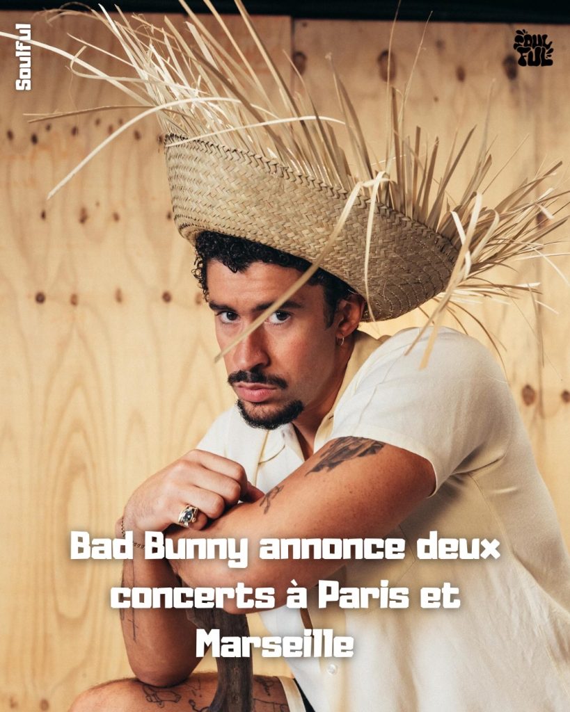 Bad Bunny portant un chapeau en paille original, assis sur un fond en bois clair, avec le texte « Bad Bunny annonce deux concerts à Paris et Marseille ».